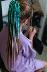 Colored braids on an elastic band on a teenage girl