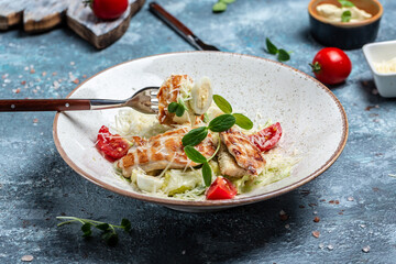 Fresh caesar salad with grilled chicken, cheese and croutons, quail eggs and cherry tomatoes. Delicious balanced food concept. top view