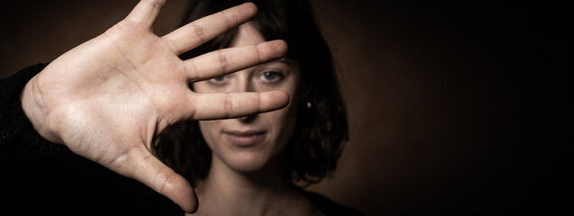 Woman showing stop sign, don't come closer gesture. Focused on hand. Emotions, body language...