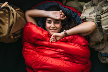 The traveler is resting in a sleeping bag. Rest concept. A tourist is resting in a tent. Woman...