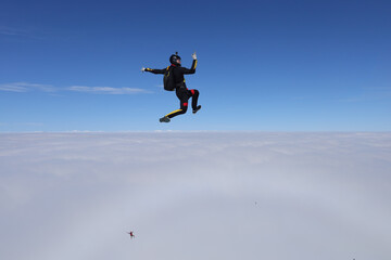 Fototapeta na wymiar Skydiving. Freefly jump. Solo skydiver is above clouds.