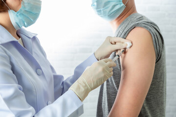 Doctor wearing protective medical mask for protection from virus disease with syringe doing...