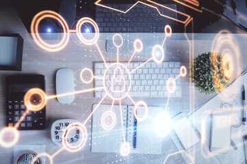 Social network hologram drawings over computer on the desktop background. Top view. Multi exposure. Concept of people connection.