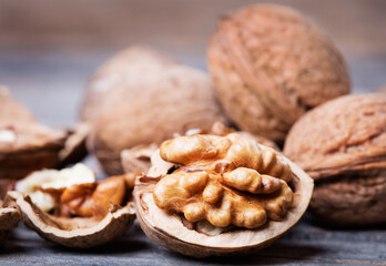 heap of walnuts with nutshell on wooden background