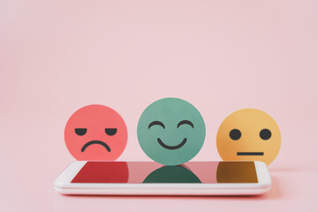 green good emotion face on blurred white mobile phone in soft focus for customer review, comment, experience, satisfaction survey, feed back concept