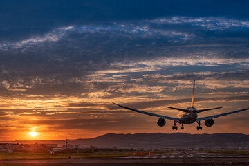 Fototapeta na wymiar 美しい夕焼けにランディングする飛行機の後ろ姿