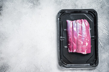 Raw lamb tenderloin in vacuum packaging. White background. Top view. Copy space