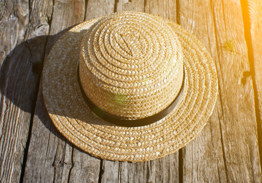 Straw hat on the wooden pier. Rustic and natural photo outdoors. Summer river. Relax and travel concept. Wanderlust, Tourists hiking.
