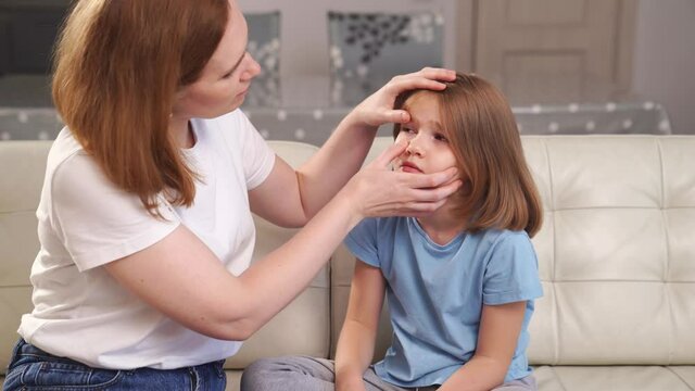 little girl complains to her mother about the pain in her eyes. 