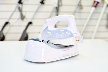 A modern wireless iron on a showcase in a home appliance store.