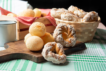 Brazil cheese bread and sweet biscuit and a cup of coffee on a table with green checkered tablecloth, selective focus.