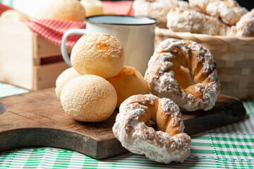 Brazil cheese bread and sweet biscuit and a cup of coffee on a table with green checkered tablecloth, selective focus.
