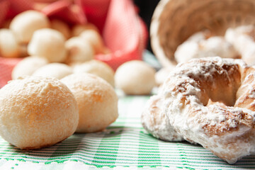Brazil cheese bread and sweet biscuit on a table with green checkered tablecloth, selective focus.