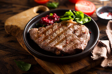 Grilled beef steak with fresh spinach