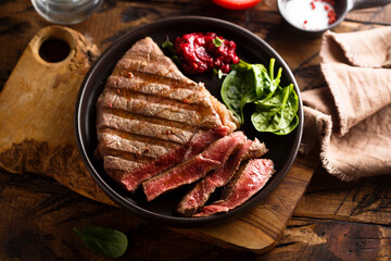 Grilled beef steak with fresh spinach