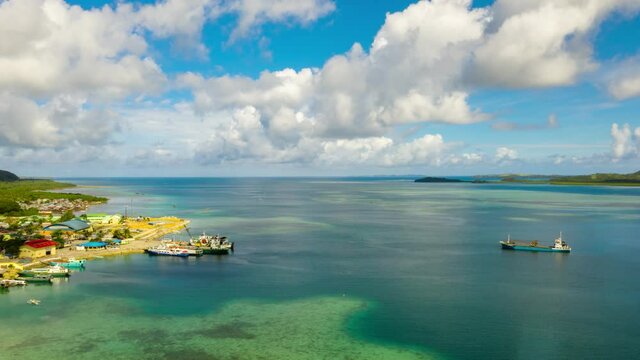 Hyperlapse: Ferry terminal with ferry and ships in the town of Dapa, Siargao island, time lapse from above. Summer and travel vacation concept