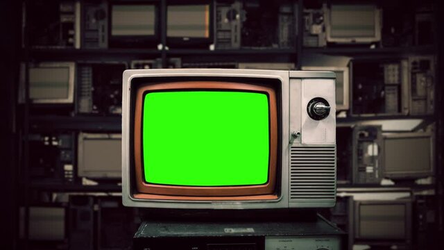 Green Screen Television Retro Revival Technology Computers. Old television green screen in front of many broken computers in the background