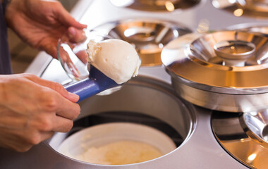 Ball of vanilla ice cream in ice cream razor in cafe