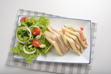 assorted sandwiches club with ham, cheese and mayo egg with salad in white background western halal menu