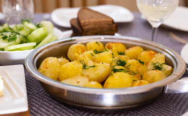 toasted young potatoes with dill in metal skillet