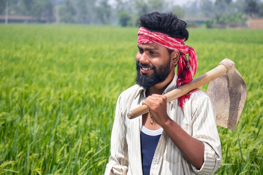 Portrait of a Farmer holding a spade on her shoulder Standing on his agriculture field