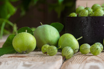 Fresh gooseberries in clay pot. Traditional clay pot cooking. Gooseberry pickle making.green gooseberry and apple on a wooden surface