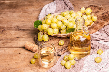 White wine and grape in a wicker basket on wooden table