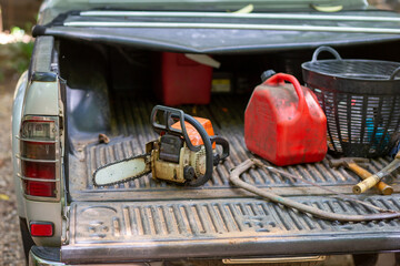 selective focus electric saw, Smallfuel tank placed in the back of the pickup truck. wood cutting go out to find firewood Gardener's cutting equipment, Thai farmers