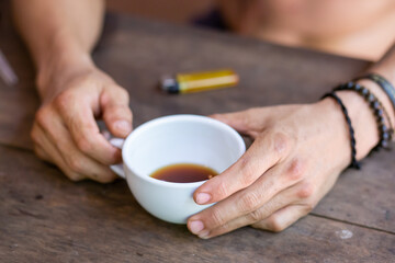 Fototapeta na wymiar selective focus male hand holding a white coffee cup placed on a wooden table Have a relaxing coffee in the morning.