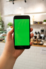 Hand holds the phone. background. Green screen. Mockup Phone. Smartphone in hand.