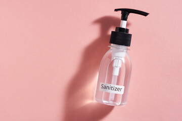 hand sanitizer pump bottle on pink background
