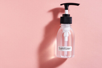 hand sanitizer pump bottle on pink background