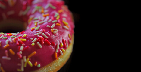 part of the pink doughnut on a black background