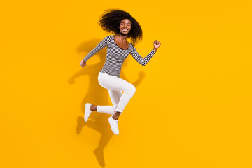 Fototapeta na wymiar Full length body size photo woman jumping high running on sale in striped shirt isolated bright yellow color background