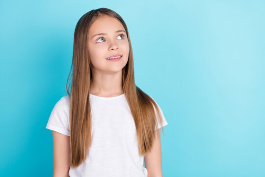 Photo of sweet brown hair small girl look empty space wear white t-shirt isolated on blue color background
