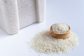 Thai jasmine rice in wooden bowl on grain pile and Container or Plastic box on white background, Keep dried storage and Agricultural organic produce, Staple food with carbohydrate of Asian people.
