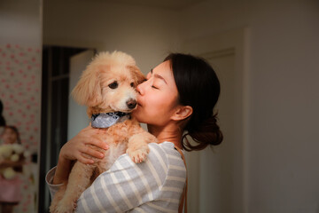 Cute young woman kisses and hugs her puppy, love between onwer and dog,animal lover concept