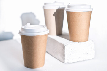 cups of coffee to go made of eco material, cardboard and reusable plastic lids. take away coffee and drinks concept. minimal style.
