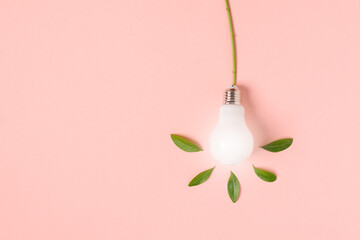 Light bulb with green leaves as a concept of eco energy. Creative idea of energy saving.