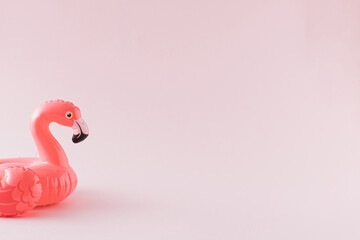 Pink flamingo toy on pastel pink background. Minimal summer concept.