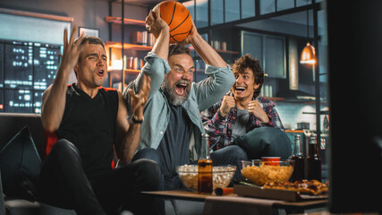 At Home Three Joyful Basketball Fans Sitting on a Couch Watch Game on TV, Celebrate Victory when Sports Team Wins Championship. Group of Friends Cheer When Favourites Play.