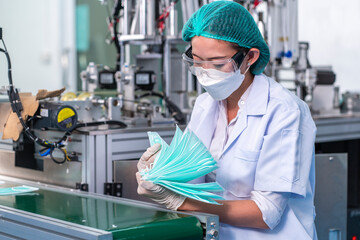 Naklejka premium Quality control female employees inspect products and control the production of masks to ensure quality in the factory. 
