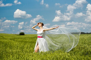 Fototapeta na wymiar Beautiful young european bride posing on the green field.
