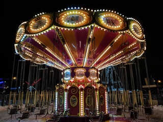 a round children's carousel glows with lights for the new year . christmas in the city © Natalia