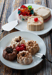 Dessert on the table, jelly on white plates over a rustic wooden table