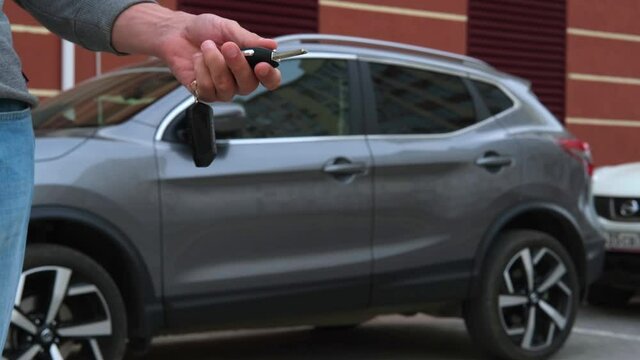 The man is holding the car keys. Car purchase, rental, insurance, car safety.