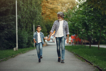 Obraz premium Grandfather with grandchild walking in a summer park