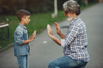 Grandfather with grandchild walking in a summer park