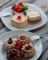 Dessert on the table, jelly on white plates over a rustic wooden table