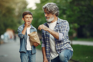 Grandfather with grandchild walking in a summer park